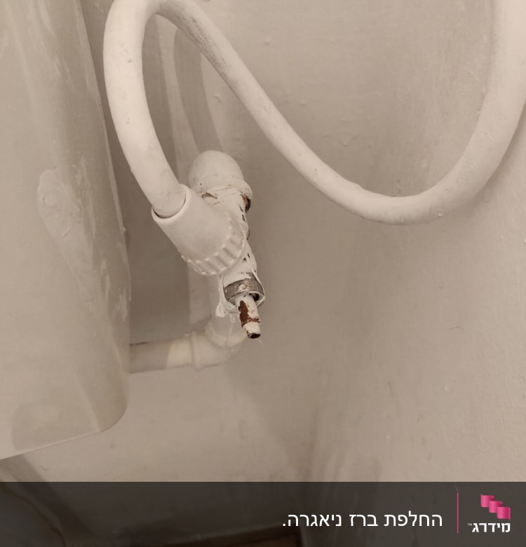 צינור מים לבן עם חיבורי ברז חלודים